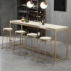 three stools and a table with wine bottles on it in front of a wall