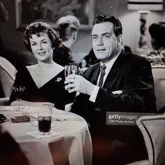 a man and woman sitting at a table with drinks in front of them stock photo