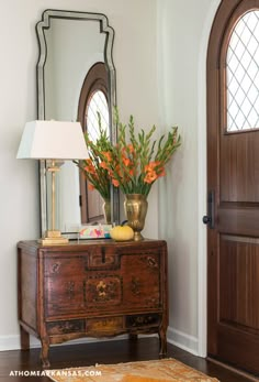 a wooden dresser sitting in front of a mirror on top of a hard wood floor