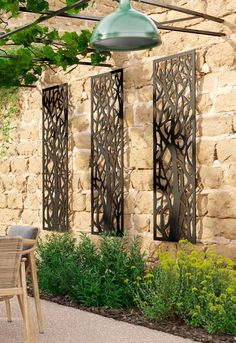 an outdoor dining area with chairs and table next to a wall made out of stone