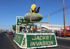 there is a float made out of flowers and grass on the side of the road