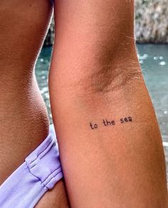 the back of a woman's left arm with an inscription to the sea on it