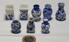 there are many blue and white vases next to a one euro coin on the table