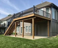 a house with a deck and stairs in the front yard