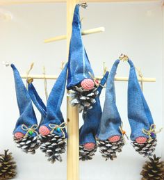 several pine cones are hanging from a clothes line with blue cloths and beads on them