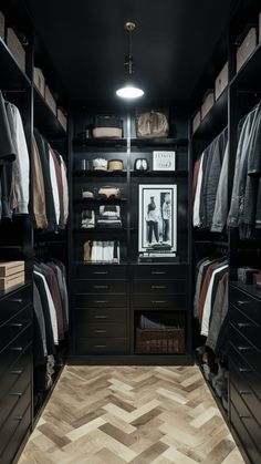 a walk - in closet with black cabinets and drawers, an area rug on the floor