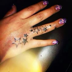 a woman's hand with stars tattooed on it