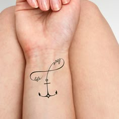 a woman's arm with an anchor tattoo on her left wrist and the word love written in cursive writing