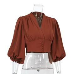 A bit of glamor and bohemian infused into this 1970s inspired blouse. The look is called Ossie and is inspired by 70s European bohemian. A classically shaped blouse that accentuates the waist and exaggerates the shoulder with that pretty sleeve.  It's almost certainly a top to wear for business or pleasure when paired with your favorite high waisted pants or skirt. Material: Polyester, rayon Product details: Short V-neck blouse, Mid-length puffed sleeves, Buttoning, Marked shoulders Imported Pro Woman Blouse Casual, Blouse Elegant, Lantern Sleeve Top, Lantern Sleeved Blouses, Puff Long Sleeves, Retro Mode, Collars For Women, Tunic Styles