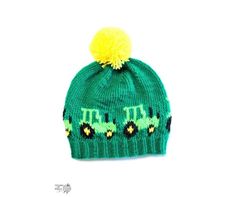 a green knitted hat with yellow pom - pom on top and the word,