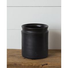 a black pot sitting on top of a wooden table