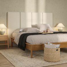 a bed with white headboard and two nightstands next to it on a rug