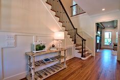 a wooden table sitting in the middle of a room next to a stair case with a tabletop on it