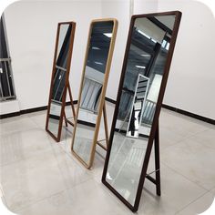 three mirrors sitting on top of a tiled floor