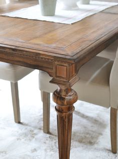 a wooden table with white chairs around it