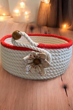 a white and red rope belt with a flower on the end, sitting on a wooden table