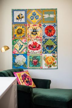 a green couch sitting in front of a colorful wall hanging