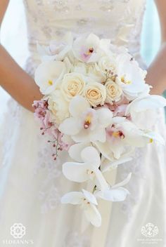 a bride holding a bouquet of white and pink flowers