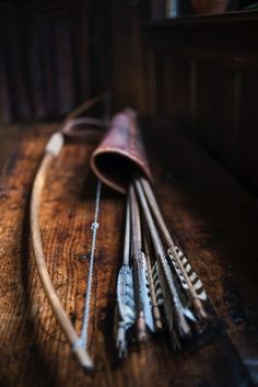 an assortment of metal arrows on a wooden table