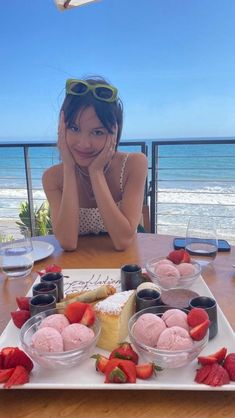 a woman sitting at a table with desserts on it