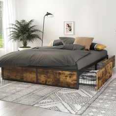 a bed that has some sort of storage underneath it in a room with white walls