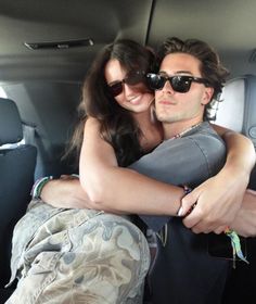 a man and woman are sitting in the back of a car with their arms around each other