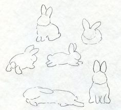 four drawings of rabbits on paper with one laying down and the other standing up in different positions