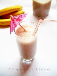 there is a smoothie in a glass with an umbrella on the table next to bananas