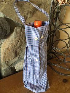 a blue and white checkered bag sitting on top of a wooden table next to a stone wall