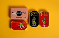 three tins that are sitting on a yellow surface