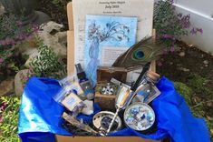 a box filled with assorted items sitting on top of a blue tarp covered ground