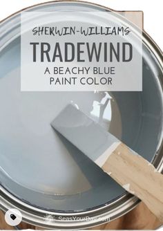 a paint can with the words tradewind painted on it and a wooden spatula