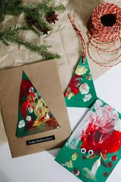 two christmas cards on a table next to some twine