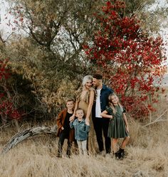 a family poses for a photo in the tall grass