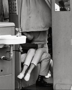 a woman sitting on the back of a train next to a sink