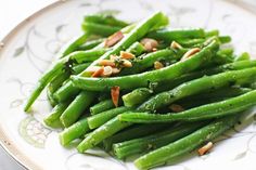 a white plate topped with green beans and nuts