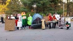 a group of people standing next to each other in front of tents with animals on them