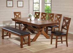 a dining room table set with bench and chairs in front of a window on top of a rug