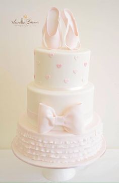 a three tiered cake with pink shoes on top