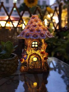 a lit up mushroom house sitting on top of a table