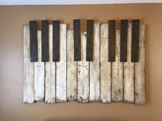 a wall hanging made out of wooden planks with black and white paint on it