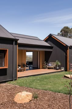 the exterior of a house with black siding and wood trimmings on the windows