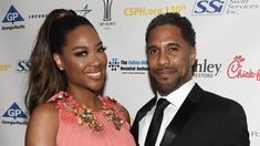 a man and woman standing next to each other in front of a red carpeted wall