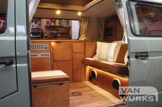 an interior view of a camper van with the door open and wood flooring