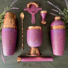 purple and gold vases with matching spoons, utensils and other items