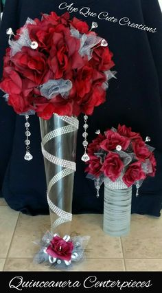 two vases filled with red flowers sitting next to each other