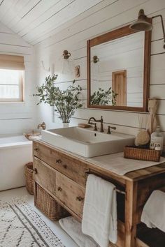 a bathroom with a sink, mirror and bathtub next to a rug on the floor