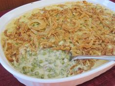 a casserole dish with broccoli and cheese in it on a red cloth