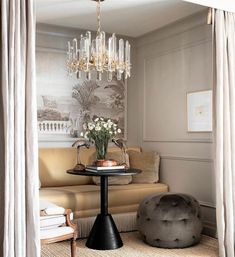 a living room filled with furniture and a chandelier hanging from the ceiling over a table