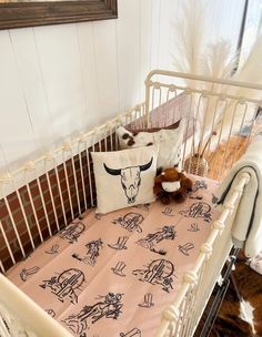 a baby crib with a stuffed animal and pillow on it's side in a room